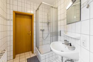 a bathroom with a sink and a toilet and a shower at Stadtgut Mölkau Rooms & Apartments in Leipzig