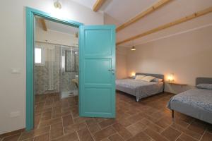 um quarto com uma cama e uma porta azul com um quarto em Al posto giusto -appartamento Gioia em Riotorto