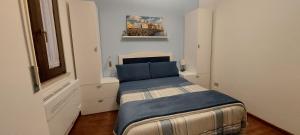 a small bedroom with a bed with a blue blanket at La Casa Blanca in Grottammare