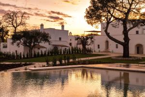 a house with a pond in front of a building at Masseria Auraterrae in Polignano a Mare