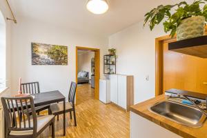 een keuken en eetkamer met een tafel en een wastafel bij Stadtgut Mölkau Rooms & Apartments in Leipzig