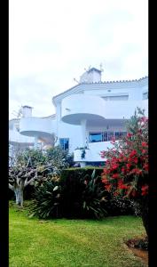 ein großes weißes Gebäude mit Blumen im Hof in der Unterkunft Mijas Holiday in Fuengirola