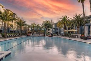 a large swimming pool with palm trees and buildings at Sunnyvale 1br w gym pool wd nr highways SFO-1330 in Sunnyvale