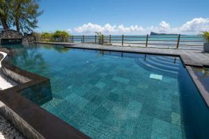 a large swimming pool with a view of the ocean at Superbe appartement en bord de plage in Bain Boeuf