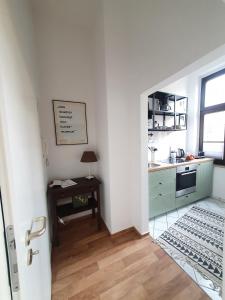 a kitchen with a sink and a table in a room at Sonniges Altstadt Nest in Magdeburg