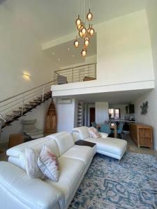 a living room with a white couch and a staircase at Superbe appartement en bord de plage in Bain Boeuf
