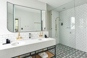 uma casa de banho com 2 lavatórios e um espelho grande em Portarlington Grand Hotel em Portarlington