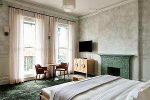 - une chambre avec un lit et une cheminée dans l'établissement Portarlington Grand Hotel, à Portarlington