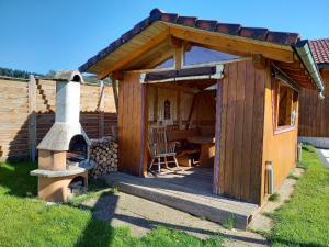 eine Holzhütte mit einem Holzofen im Hof in der Unterkunft Ferienhaus Kaltenbach in Titisee-Neustadt