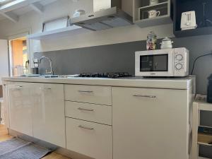 cocina blanca con microondas y fogones en Casa161 en Bolonia