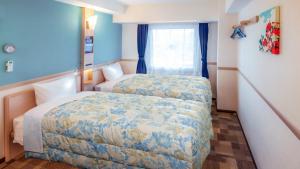 Tsushimaにある東横INN対馬比田勝のベッド2台と窓が備わるホテルルームです。