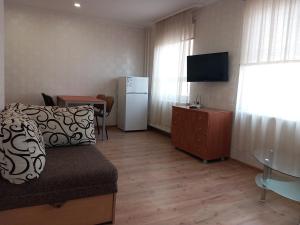 a small living room with a refrigerator and a table at Sunny Ventspils 21 in Ventspils