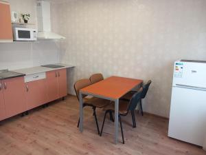 a kitchen with a table and chairs and a refrigerator at Sunny Ventspils 21 in Ventspils