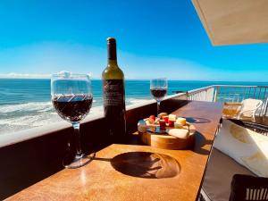 two glasses of wine sitting on a table with the ocean at ABSOLUTELY STUNNING! ON THE BEACH !!! in Gold Coast