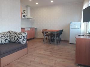 a living room with a couch and a table and a kitchen at Sunny Ventspils 21 in Ventspils