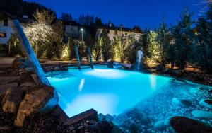 a swimming pool lit up at night with lights at Hotel Gasthof Höllriegl in Sarntal
