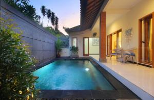a swimming pool in the backyard of a house at Shine Villa Sanur in Sanur