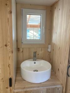 a bathroom with a white sink and a window at Camping le Petit Liou Sites & Paysages in Baratier