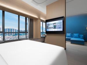 Cette chambre comprend un lit et une télévision à écran plat. dans l'établissement Country Inn & Suites by Radisson - Taishan East Branch, à Taishan