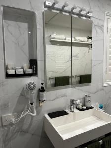 a white bathroom with a sink and a mirror at Luxury Boutique Self-Contained Private Granny Flat in Ormeau