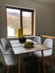 a wooden table with a plate of bananas on it at Eakie House Apartments - Kinlochleven in Kinlochleven