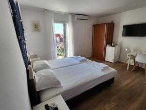 a bedroom with a large bed and a window at Apartmani Neva Supetar in Supetar