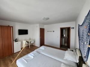a hotel room with a bed and a table at Apartmani Neva Supetar in Supetar