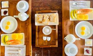 a table with plates of breakfast foods and eggs at Flexi Lodge in Negombo