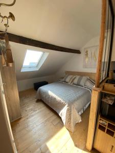 an attic bedroom with a bed and a window at Villa Etiennette 2 in Le Crotoy