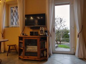 sala de estar con TV y estante de libros con ventana en Ferienwohnung Pillasch 24306 Niede en Malente