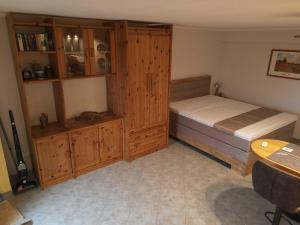1 dormitorio con 1 cama y armarios de madera en Ferienwohnung Pillasch 24306 Niede, en Malente