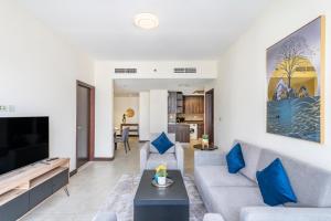 a living room with a couch and a tv at Goldcrest Views - 2BR Apartment - Allsopp&Allsopp in Dubai