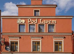 a red building with a pool tavern sign on it at Apartamenty Pod Lwem in Świdnica