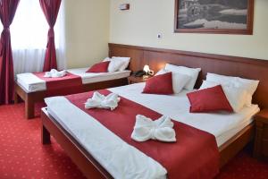 two beds in a hotel room with white and red sheets at Dolce Vita in Budva
