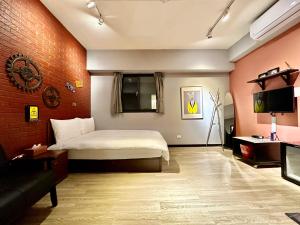 1 dormitorio con cama, sofá y TV en 御旅 Inn en Taichung