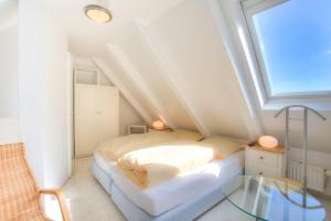 um pequeno quarto no sótão com uma cama e uma mesa de vidro em Abaco 2N - a83653 em Wenningstedt