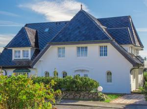 uma casa branca com um telhado preto em Abaco 2N - a83653 em Wenningstedt
