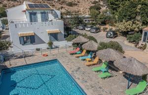 an aerial view of a swimming pool with chairs and umbrellas at Hotel Coral Matala in Matala