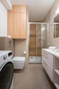 W łazience znajduje się umywalka i pralka. w obiekcie RentPlanet - Apartamenty Górna Resorts w Szklarskiej Porębie