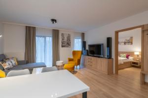 ein Wohnzimmer mit einem Sofa und einem TV in der Unterkunft RentPlanet - Apartamenty Górna Resorts in Szklarska Poręba