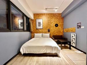 1 dormitorio con 1 cama y 1 silla en 御旅 Inn en Taichung