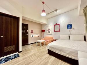 a bedroom with a bed and a couch in a room at 遇旅 House in Taichung