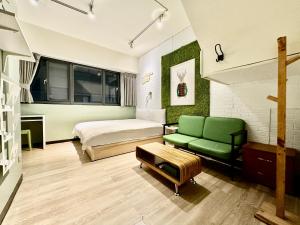 a bedroom with a bed and a green couch at 御旅 Inn in Taichung