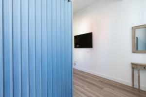 una camera con porte scorrevoli blu e TV di Holi-Rent AT Erillas a Camas