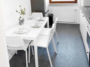 Una mesa de comedor blanca con sillas blancas en la cocina en # VAZ Apartments WU10 für Monteure Küche, TV, WLAN, Parkplatz, Autobahnähe en Schwelm