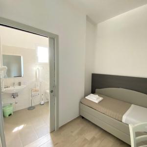 ein Schlafzimmer mit einem Bett und ein Badezimmer mit einem Waschbecken in der Unterkunft Hotel Bed and Book in Rimini