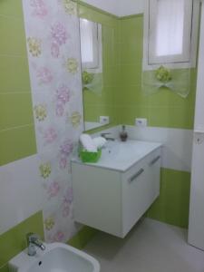 W łazience znajduje się umywalka i lustro. w obiekcie Casa Giada w mieście Porto Cesareo