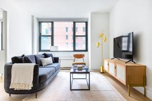 a living room with a blue couch and a tv at Murray Hill 1BR w Doorman Gym Pool Parking NYC-583 in New York