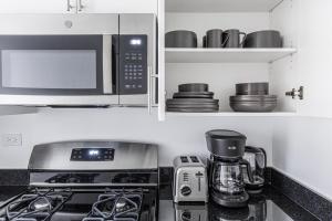 a kitchen with a microwave and a stove top oven at Murray Hill 1BR w Doorman Gym Pool Parking NYC-583 in New York