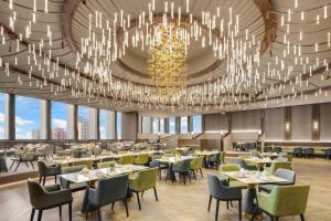 a dining room with tables and chairs and chandeliers at Kaohsiung Marriott Hotel in Kaohsiung